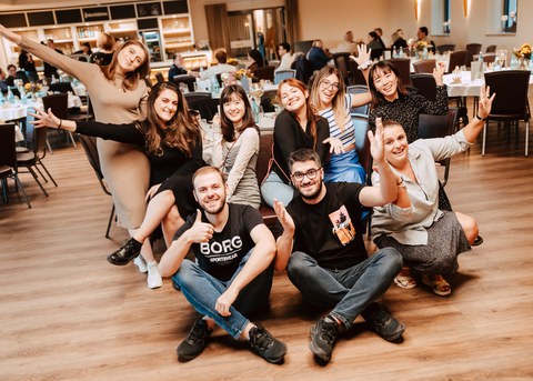 Doktoranden-Gruppe im Schneidersitz auf dem Boden zum Gruppenfoto