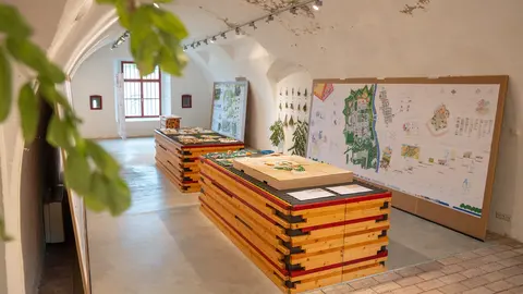 Blick in Ausstellungsraum mit Plakaten und Modellen