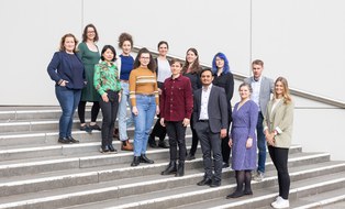 Gruppenfoto mit 13 Personen auf einer Treppe 