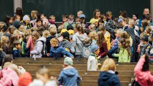 Kinder in einem Hörsaal.