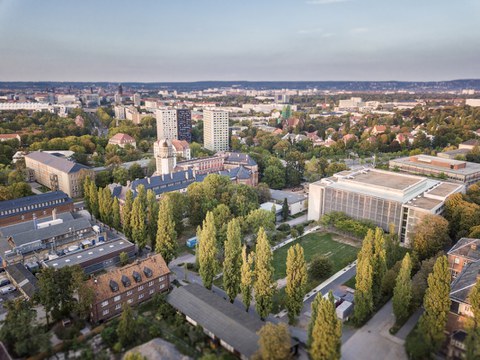 Das Foto zeigt eine Luftaufnahme einiger Gebäude der TU Dresden. Unter anderem kann man das Hörsaalzentrum mit seiner großen Wiese erkennen.