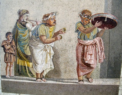 Das Bild zeigt ein Mosaik einer antiken Szene mit vier Personen, die mit antiken Instrumenten musizieren.