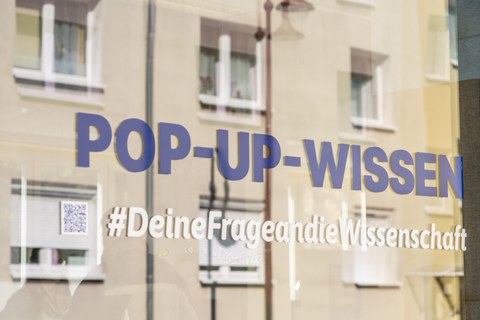 Ein Schaufenster mit der Beklebung POP-UP-WISSEN Hashtag Deine Frage an die Wissenschaft