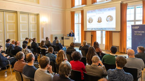 Präsentation einer weiblichen Personen mit gefüllten Auditorium im Festsaal Rektorat TUD