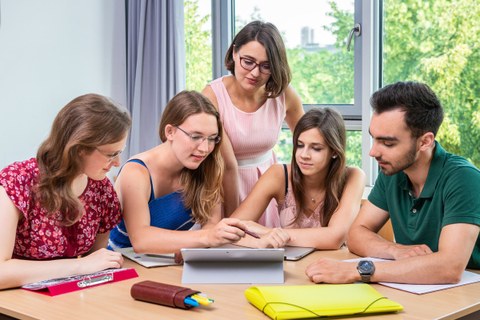 Fünf Studierende gemeinsam an einem Tisch im Gespräch