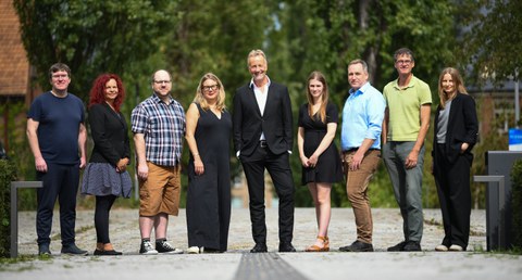 10 Teammitglieder vor einem Gebäude
