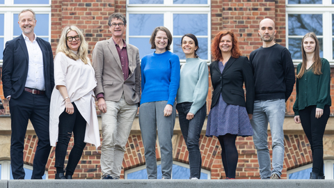 10 Teammitglieder vor einem Gebäude