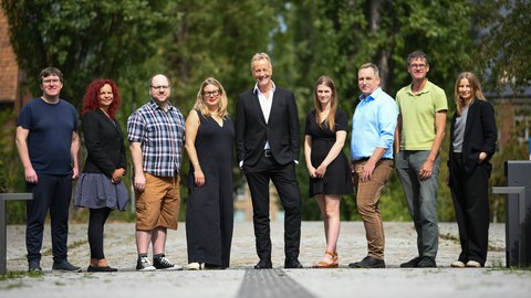 10 Teammitglieder vor einem Gebäude
