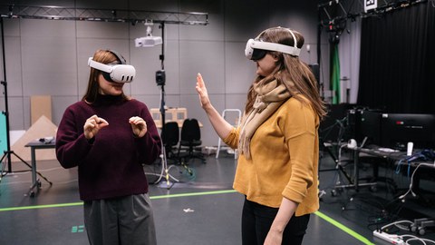 Zwei Personen mit Virtual Reality Brillen, die in einem Raum stehen
