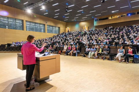 Professor Dr Roswitha Böhm in front of the packed Audimax