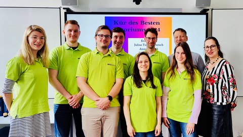 Foto von Personen vor einem Smartboard, im Hintergrund zu lesen Kür des besten Tutoriums 2024