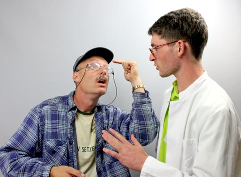 Fordernder Patient steht gestikulierend vor Arzt