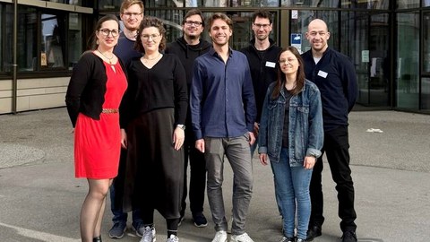 8 Personen vor einem Gebäude auf dem Campus der TU München - v.l.n.r.: Marie-Christin Willemer (Leiterin MITZ), Tutor:innen Julius, Sarah, Eric, Jonas, Raphael und Anne sowie Mathias Bleier-Rox (SP-Programm MITZ)