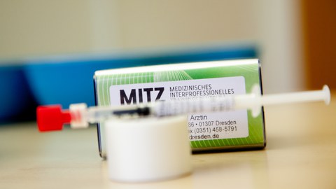 Stempel MITZ und Spritze deuten auf die Impfaktion gegen Corona hin