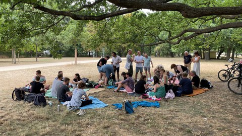 MITZ-Mitarbeiter:innen auf Picknick-Decken im großen Garten