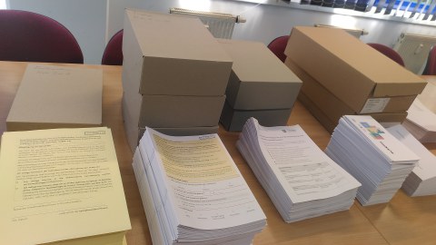auf einem Tisch liegen mehrere Stabel Papier, 