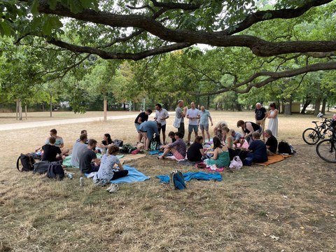 MITZ-Mitarbeiter:innen auf Picknick-Decken im großen Garten