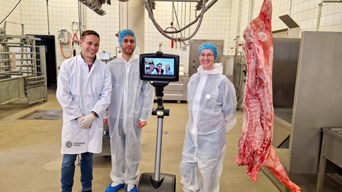 Telepräsenzroboter in der Schlachthalle der Veterinärmedizin der Universität Leipzig neben 3 Personen und einem geschlachteten Tier