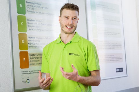 MITZ-Peer-Tutor als Lehrender vor einem Lehrposter