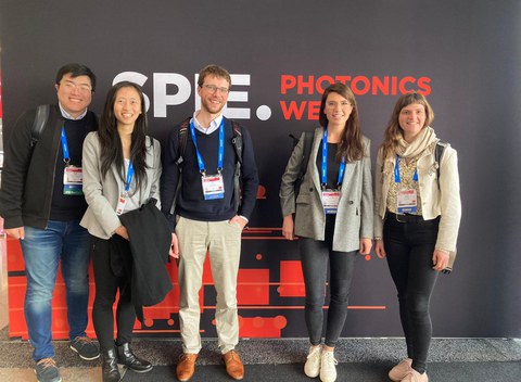 Das Foto zeigt fünf Personen vor einer Wand mit der Aufschrift SPIE Photonics West Conference.