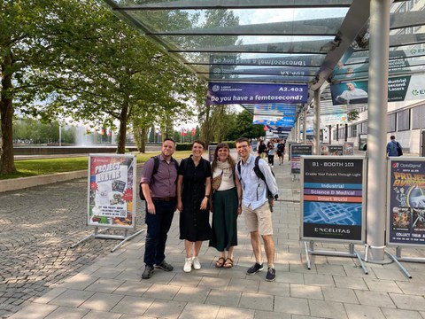 Das Foto zeigt vier Personen vor dem Eingang zur Messe München.