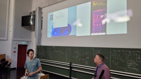 Auf dem Foto sind zwei Personen bei der Weihnachtsvorlesung der Physik zu sehen.