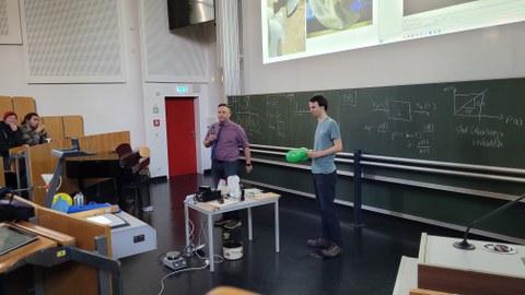 Auf dem Foto sind zwei Personen bei der Weihnachtsvorlesung der Physik zu sehen.