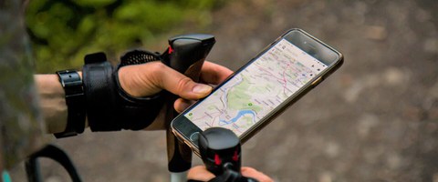 Hände eines Walkers mit Stöcken und Mobiltelefon