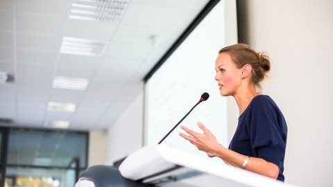 Junge Wissenschaftlerin hält einen Vortrag