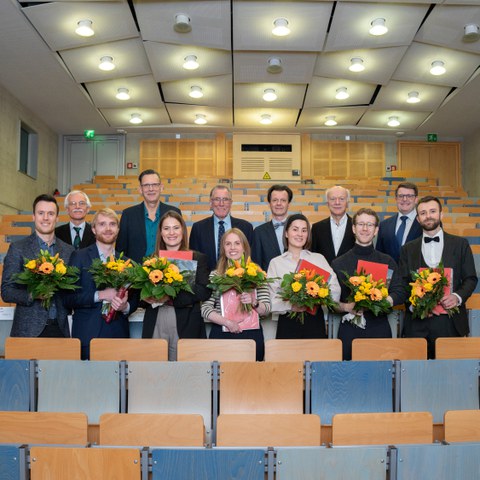 Preisträgerinnen und Preisträger gemeinsam mit den Laudatoren bei einem Gruppnbild im Hörsaal