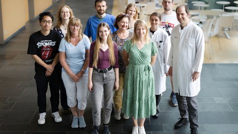 Ein Gruppenfoto von Forschenden, einige haben weiße Laborkittel an.