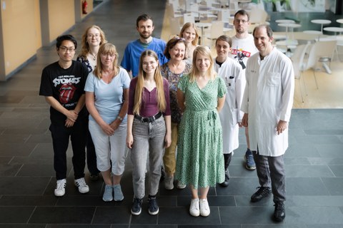 Ein Gruppenfoto von Forschenden, einige haben weiße Laborkittel an.