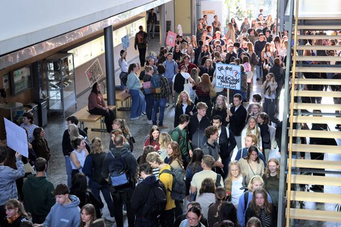 Viele junge Menschen drängen sich in einem Gebäude.