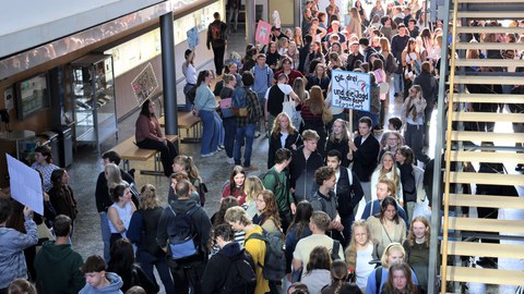 Viele junge Menschen drängen sich in einem Gebäude.