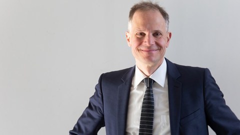 Foto vom Jochen Schmitt: Eine Person schaut lächelnd in die Kamera.