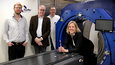 Vier Personen stehen rund um ein MRT-Gerätprototyp.
