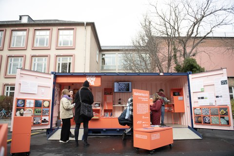 Geöffnete Wanderausstellung Bakteriopolis, Besucher:innen im Gespräch über Exponate