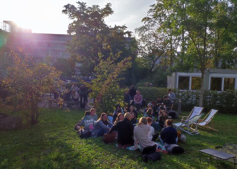 Gruppe sitzt auf dem Rasen