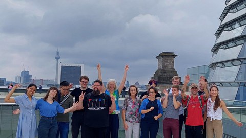 Gruppe von Leuten mit Fernsehturm im Hintergrund