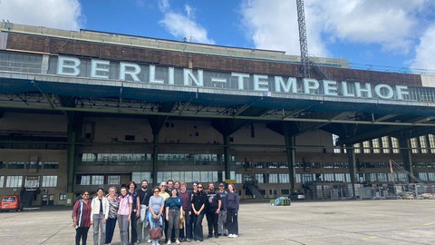eine Gruppe vor einem Gebäude mit der Aufschrift Berlin-Tempelhof