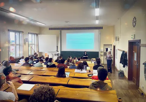 Ein Foto von einem Hörsaal mit Publikum und zwei Vortragenden