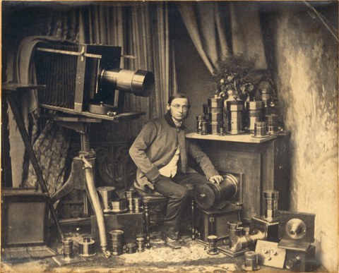 Ein Portrait Hermann Krones zwischen seinen fotografischen Apparaten, Kameras und Objektiven