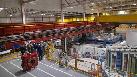 Eine Personengruppe in einer großen Werkhalle am CERN
