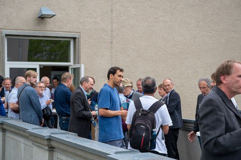 Auf der Dachterrasse des Recknagel-Baus stehen Menschen bei einem Empfang.