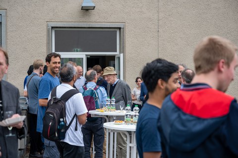 Auf der Dachterrasse des Recknagel-Baus stehen Menschen bei einem Empfang.