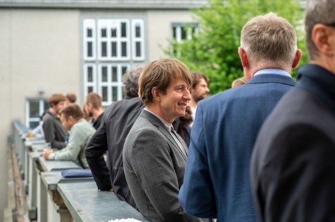 Auf der Dachterrasse des Recknagel-Baus stehen Menschen bei einem Empfang.