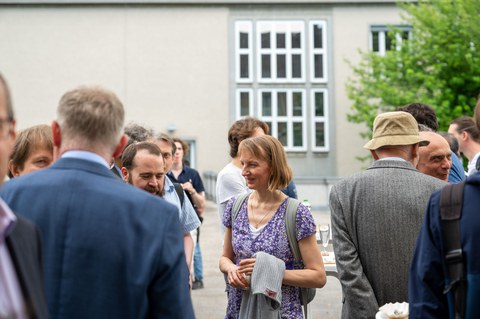Auf der Dachterrasse des Recknagel-Baus stehen Menschen bei einem Empfang.
