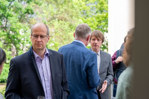 Auf der Dachterrasse des Recknagel-Baus stehen Menschen bei einem Empfang.
