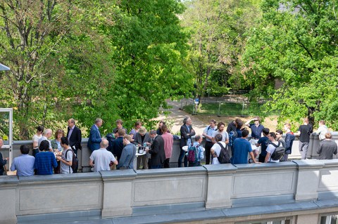 Auf der Dachterrasse des Recknagel-Baus stehen Menschen bei einem Empfang.