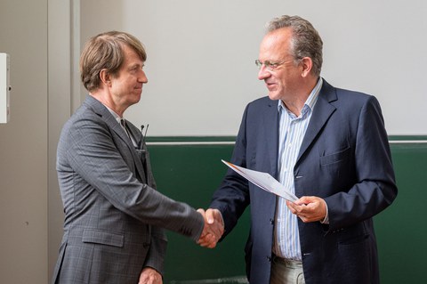 Prof. Moessner überreicht eine Urkunde an Prof. Prosen